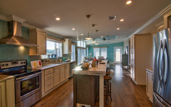Through the barn doors of the Riviera II, you get a wide open view of the primary living space as well as the gorgeous scenery through the many windows beyond.